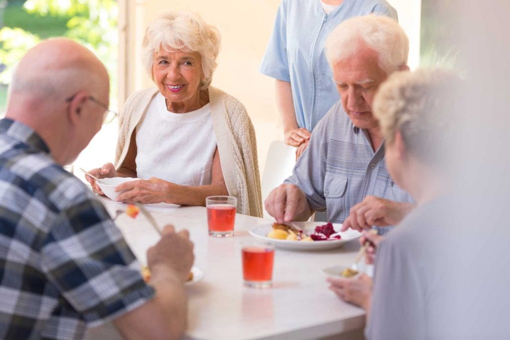 Group of elderly people eating dinner.